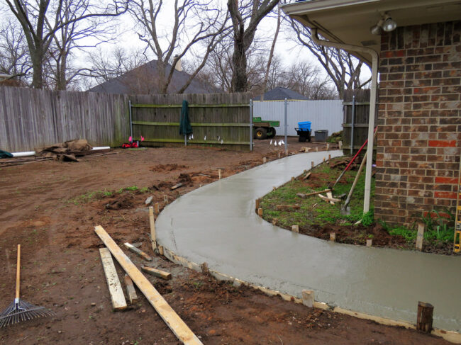 Concrete sidewalk being constructed with wood frame and cement